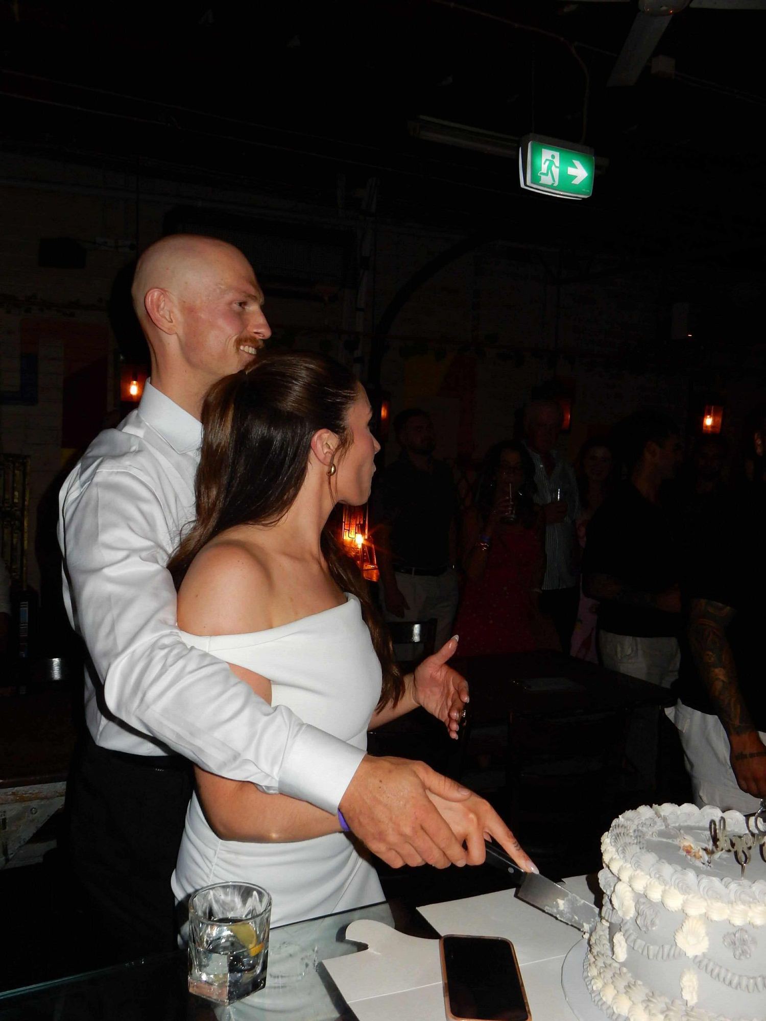 Reece and Robyn cutting their engagement-party cake